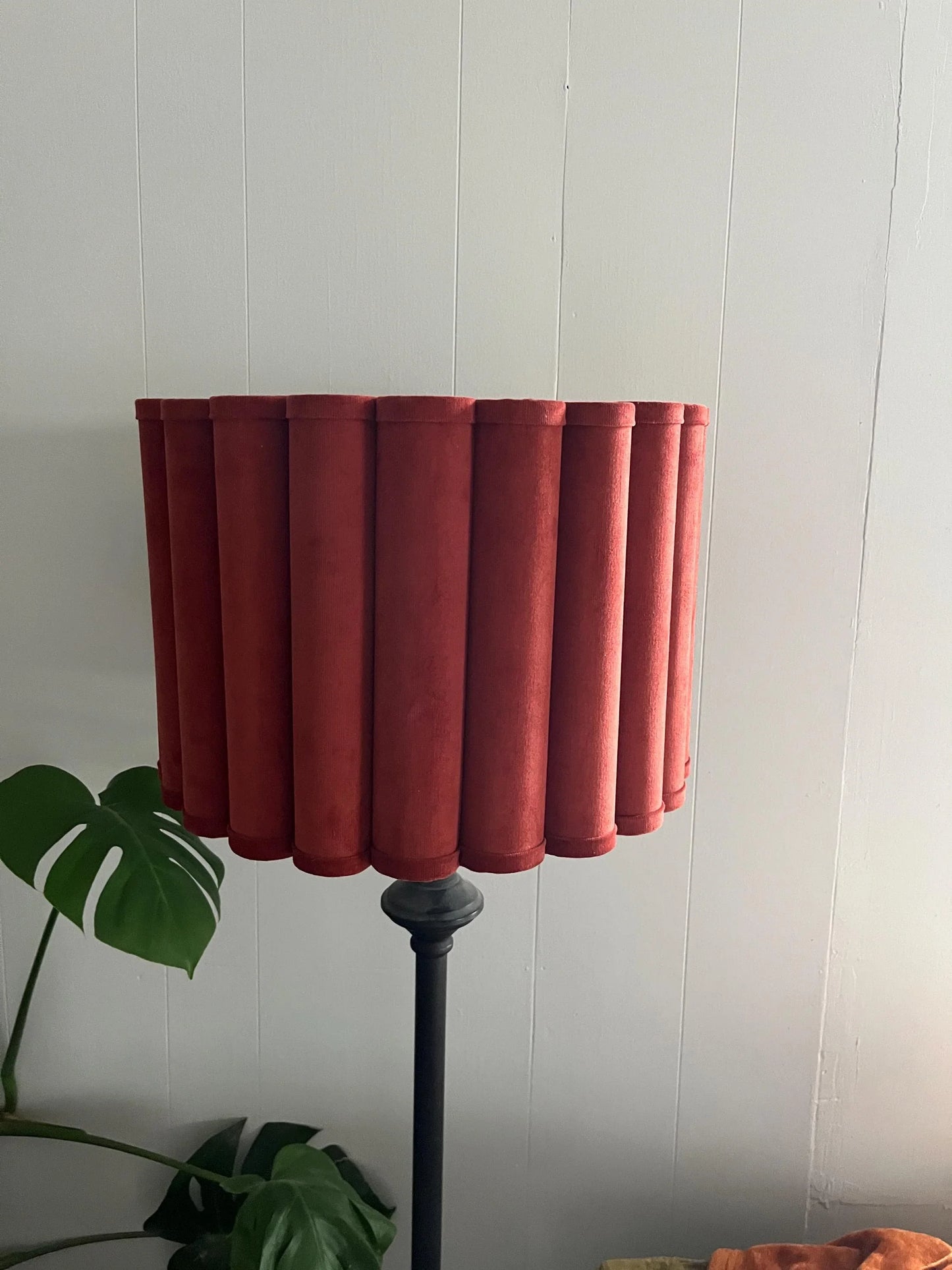 Rust velvet pleated lampshade on black floor lamp, modern home decor with monstera leaf