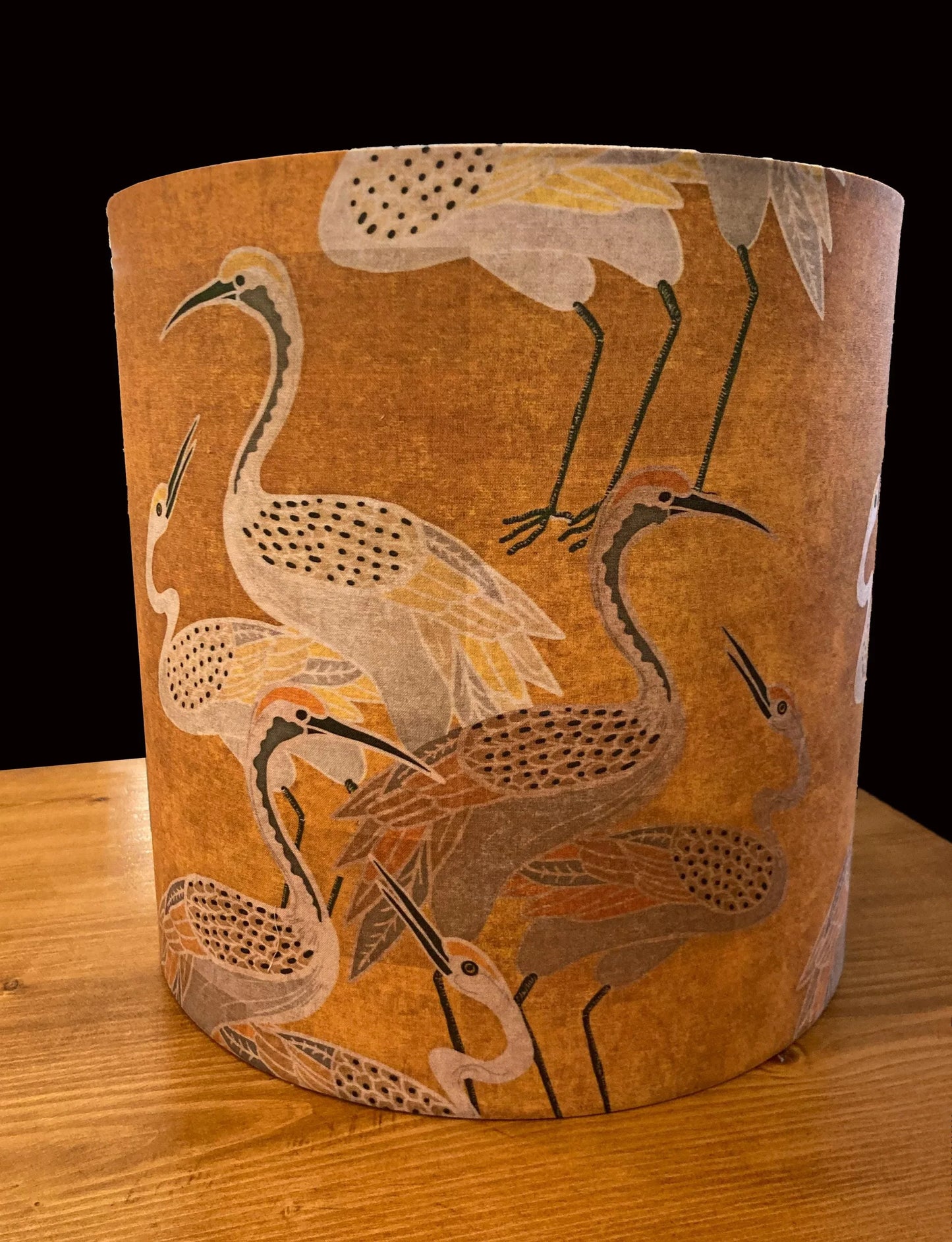 Cylindrical lampshade with elegant crane bird pattern on warm brown fabric, perfect for nature-inspired home decor